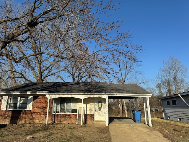 single story home with brick siding, an attached carport, and concrete driveway