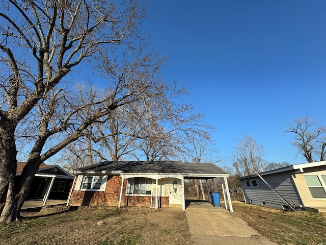 view of front of house featuring brick siding and concrete driveway