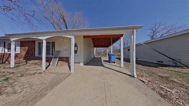 exterior space with brick siding, an attached carport, and driveway