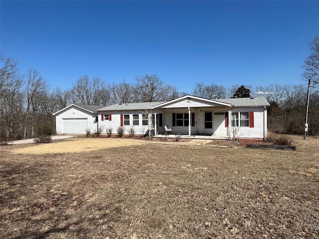 ranch-style house featuring covered porch and a garage