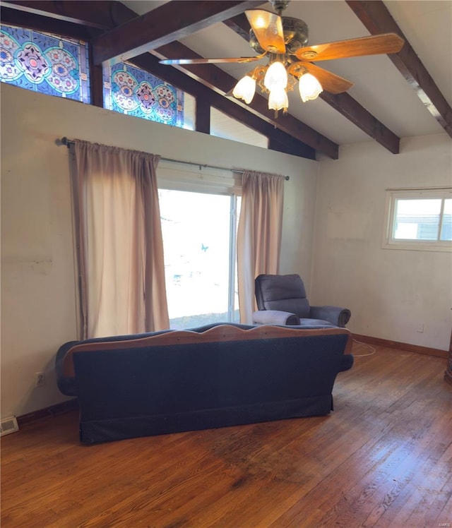 living area featuring ceiling fan, lofted ceiling with beams, baseboards, and wood finished floors