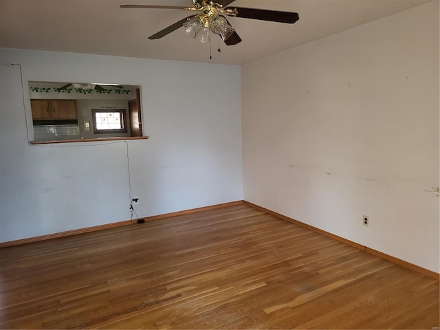 spare room with a ceiling fan, baseboards, and wood finished floors