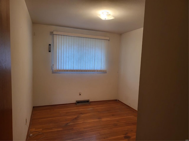 unfurnished room with visible vents and wood finished floors