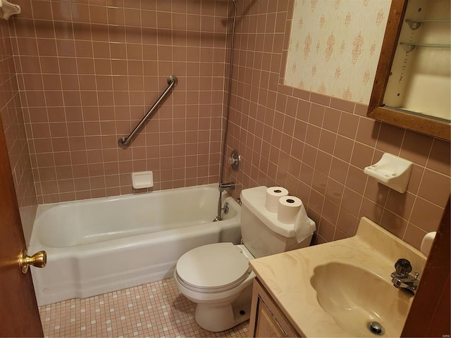 bathroom featuring tile patterned flooring, tub / shower combination, toilet, vanity, and tile walls