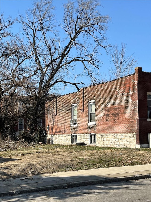 exterior space with brick siding and cooling unit