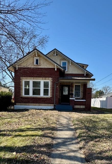 view of front of house with fence and brick siding