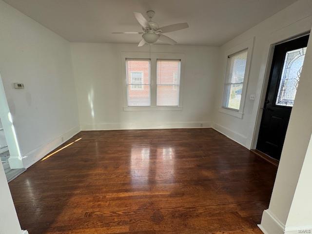 unfurnished room featuring a ceiling fan, wood finished floors, and baseboards