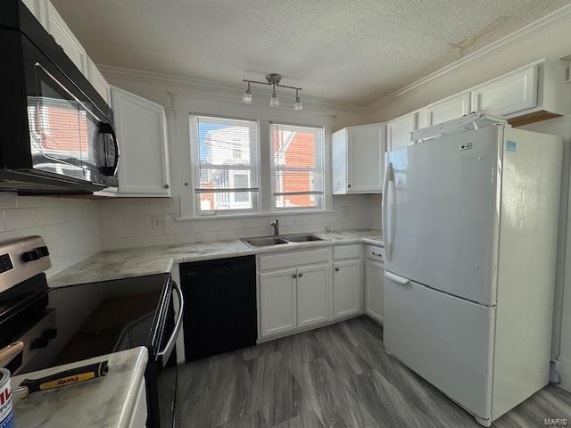 kitchen featuring black appliances, ornamental molding, a sink, white cabinets, and light countertops