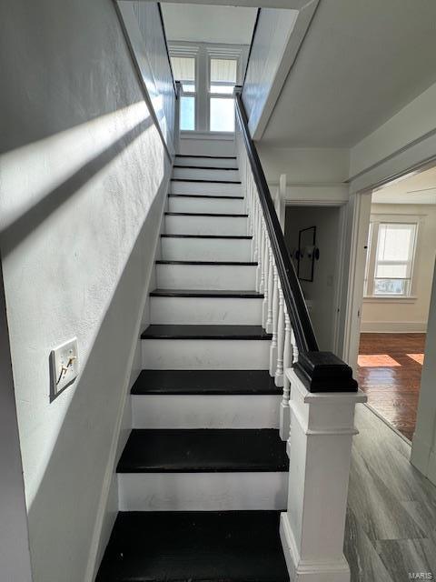 stairway featuring wood finished floors and baseboards