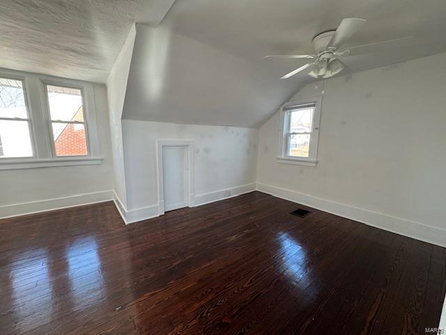 bonus room with lofted ceiling, dark wood-style floors, baseboards, and ceiling fan