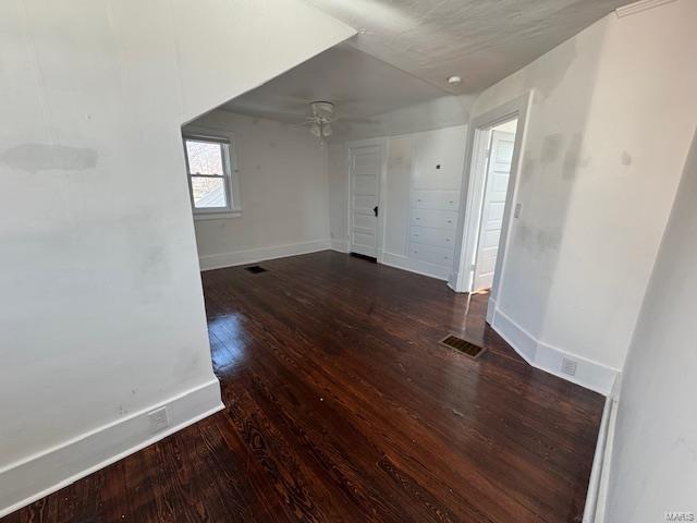 spare room with a ceiling fan, wood finished floors, and baseboards