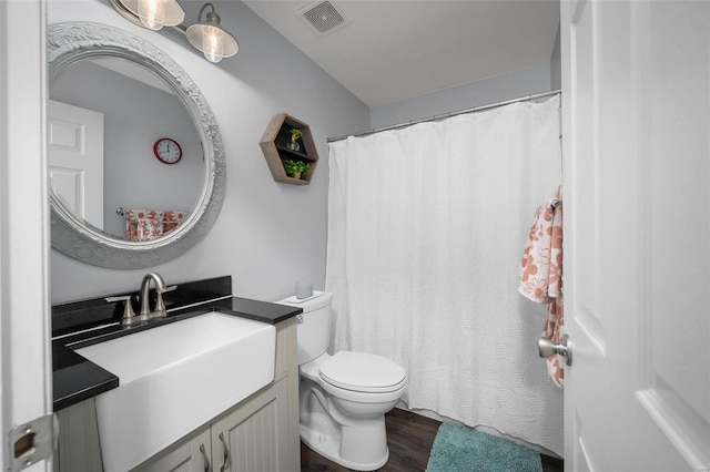 full bath with vanity, a shower with curtain, wood finished floors, visible vents, and toilet