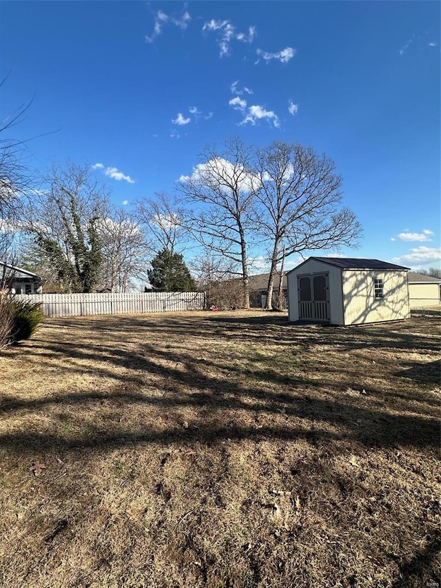 view of yard with a storage unit, an outdoor structure, and fence