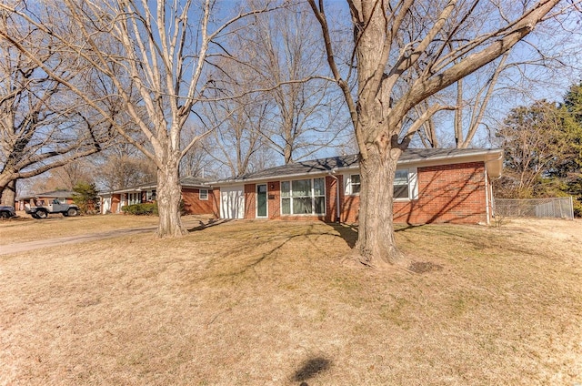 single story home featuring brick siding, a front lawn, and fence