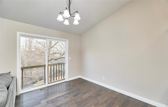 unfurnished dining area featuring visible vents, dark wood-type flooring, an inviting chandelier, baseboards, and vaulted ceiling