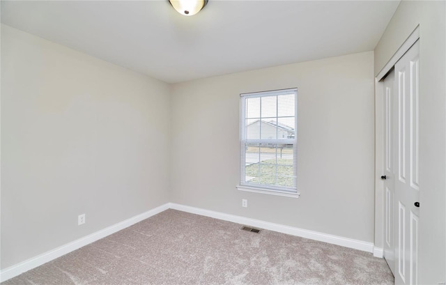 unfurnished bedroom with a closet, visible vents, carpet flooring, and baseboards