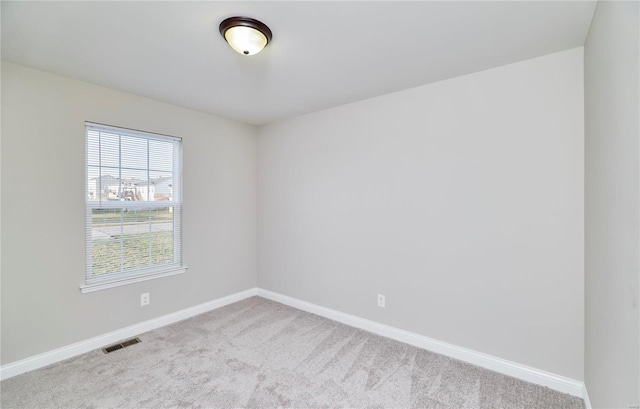 carpeted empty room with visible vents and baseboards