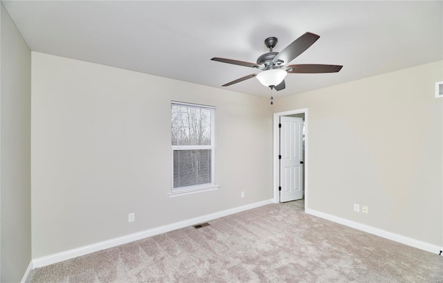 carpeted spare room featuring visible vents, ceiling fan, and baseboards