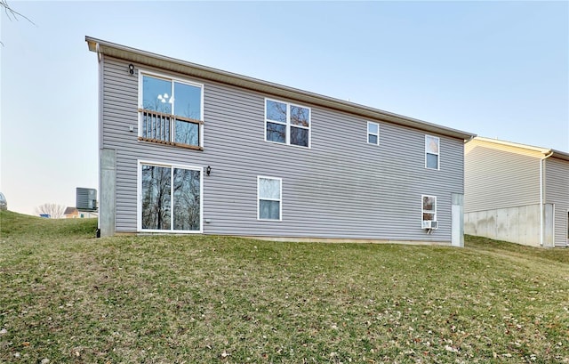 back of property featuring central AC unit and a lawn