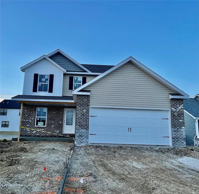 traditional home with brick siding, an attached garage, board and batten siding, and dirt driveway