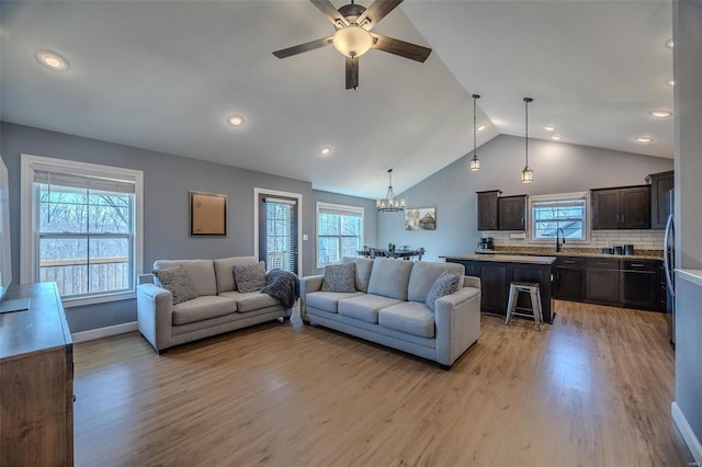 living room featuring a wealth of natural light, light wood finished floors, and lofted ceiling