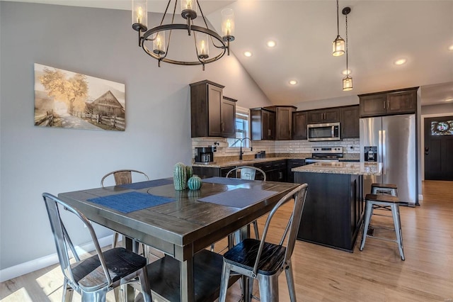 dining room featuring baseboards, recessed lighting, light wood-style flooring, an inviting chandelier, and high vaulted ceiling