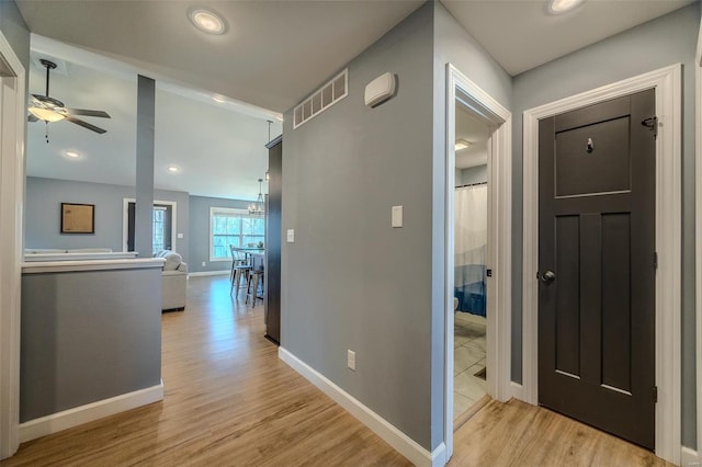 hall with visible vents, baseboards, recessed lighting, an inviting chandelier, and light wood-style floors