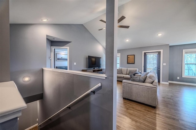 living area with a ceiling fan, wood finished floors, baseboards, recessed lighting, and vaulted ceiling