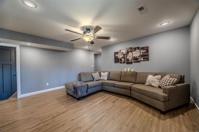 living area with baseboards, a ceiling fan, visible vents, and light wood-type flooring