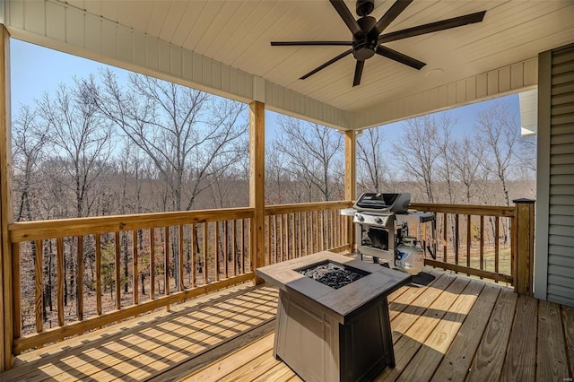 wooden deck with a fire pit, a grill, and ceiling fan