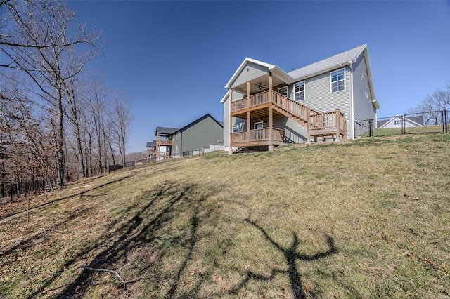 rear view of house featuring a gate, fence, a yard, ceiling fan, and a deck