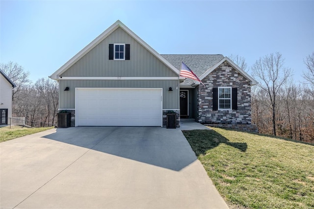 view of front of property featuring an attached garage, a shingled roof, a front lawn, concrete driveway, and stone siding