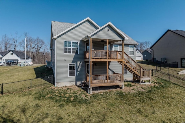 rear view of property with a lawn, a deck, a ceiling fan, a fenced backyard, and stairway