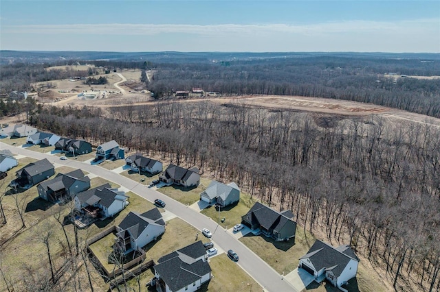 drone / aerial view with a wooded view and a residential view