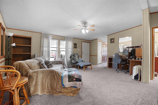 living area with ceiling fan, carpet, ornamental molding, and a textured ceiling