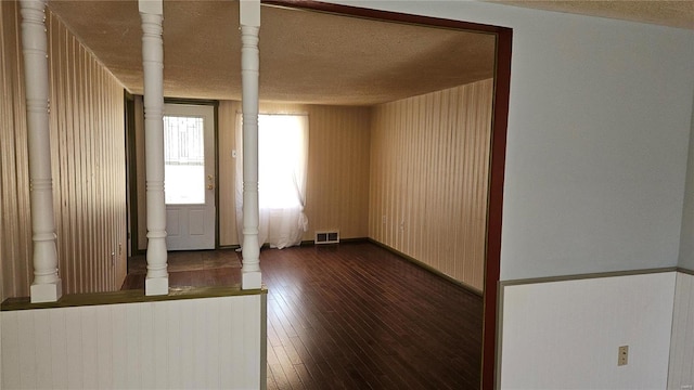 entryway featuring visible vents, baseboards, a textured ceiling, and dark wood-style floors