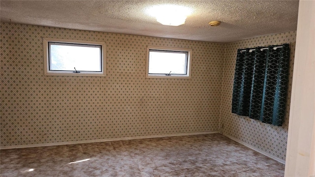 unfurnished room featuring baseboards, a textured ceiling, carpet, and wallpapered walls