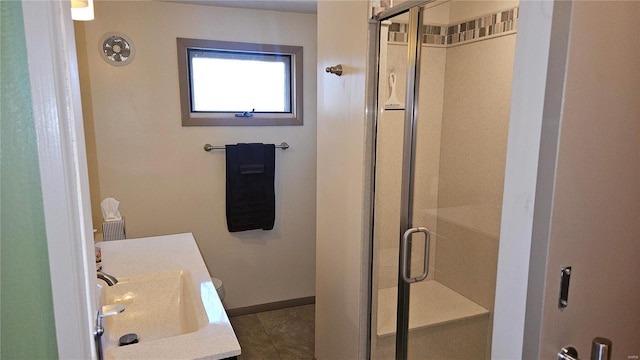 bathroom with baseboards, a stall shower, and vanity