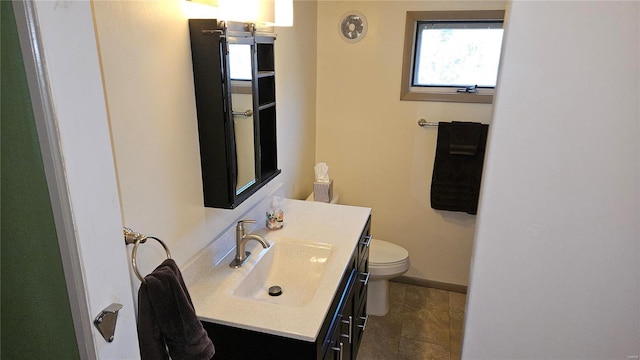 bathroom featuring tile patterned flooring, toilet, vanity, and baseboards