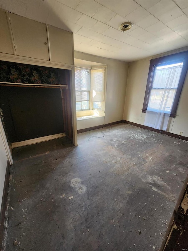 unfurnished living room featuring baseboards and plenty of natural light