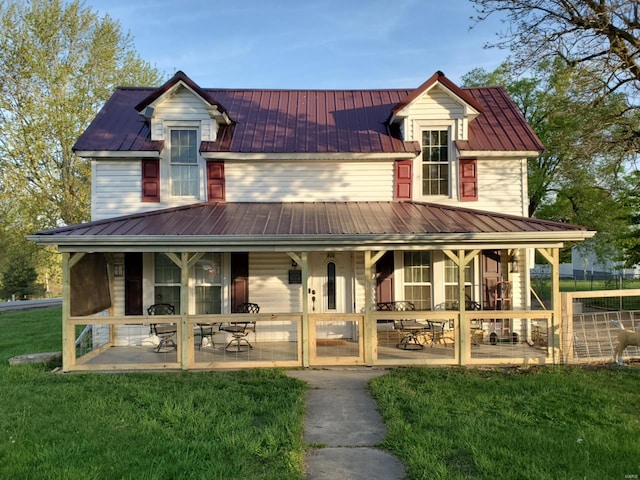 farmhouse-style home featuring a front yard and metal roof