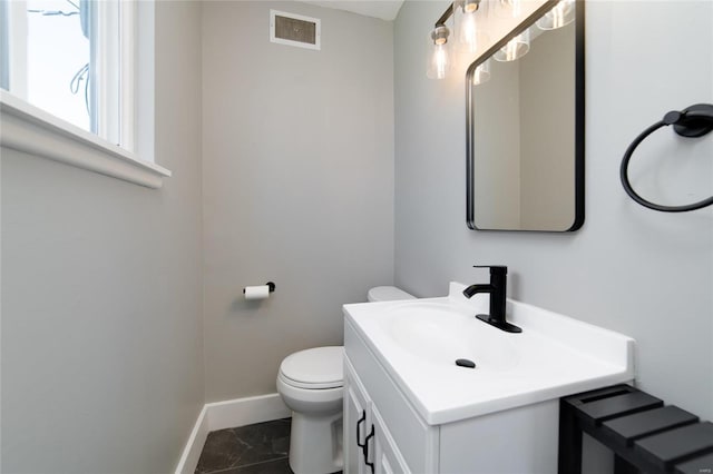 bathroom featuring visible vents, toilet, vanity, and baseboards