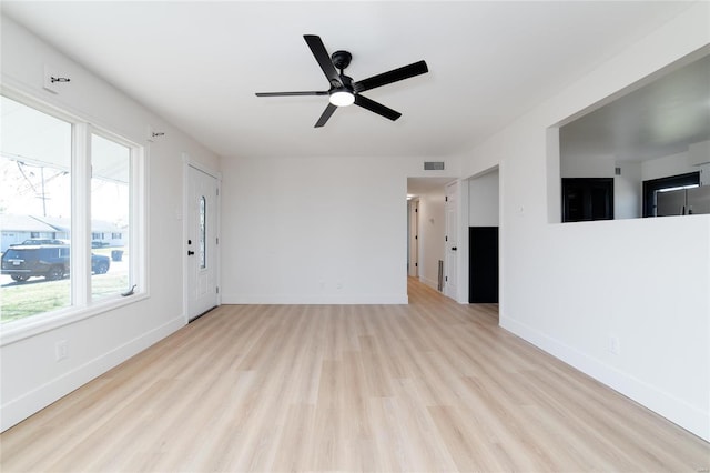 unfurnished living room featuring visible vents, a ceiling fan, baseboards, and wood finished floors