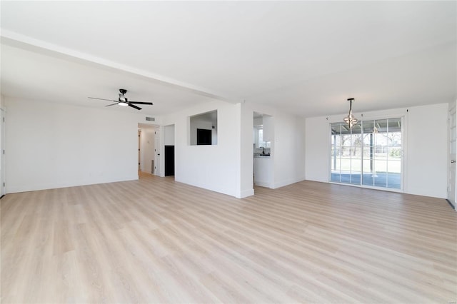 unfurnished living room with light wood-style flooring, ceiling fan with notable chandelier, visible vents, and baseboards