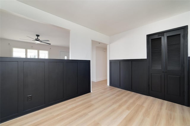 spare room featuring wainscoting, a ceiling fan, and wood finished floors