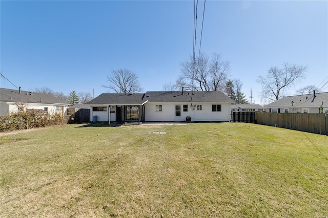 back of house featuring a lawn and fence