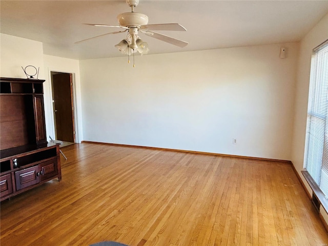 unfurnished living room with light wood-style flooring, baseboards, and ceiling fan