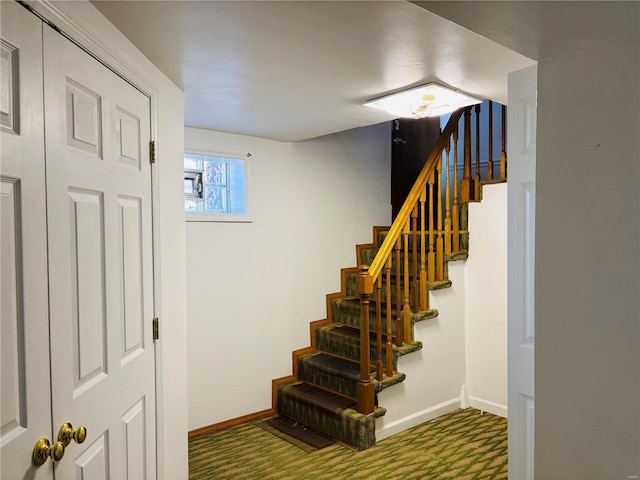 staircase featuring carpet and baseboards