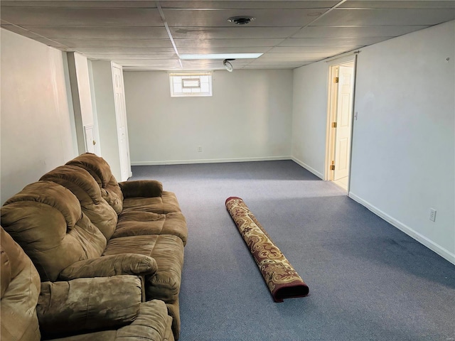 basement with carpet flooring, a paneled ceiling, and baseboards