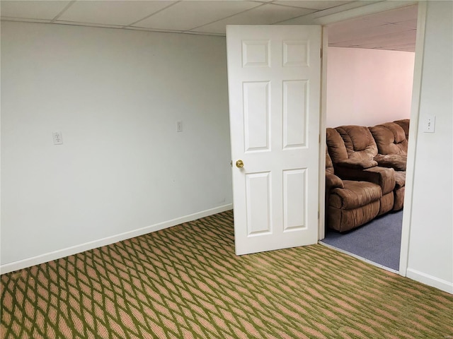 empty room with a drop ceiling, baseboards, and carpet floors